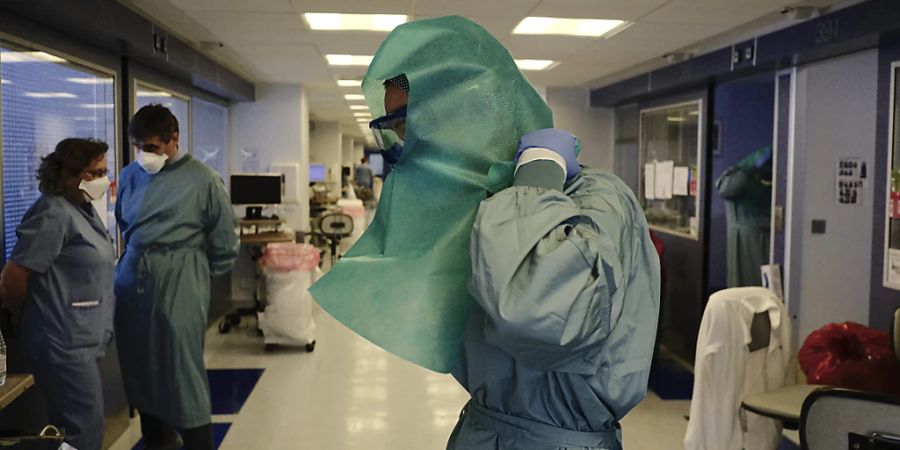Ein medizinischer Mitarbeiter zieht sich Schutzkleidung auf der Intensivstation der «Clinica Universitaria» an. Foto: Alvaro Barrientos/AP/dpa