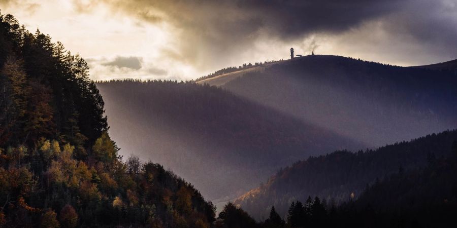 Die Sonnenstrahlen der tiefstehenden Herbstsonne streifen den Feldbergturm auf dem Gipfel des Feldbergs.