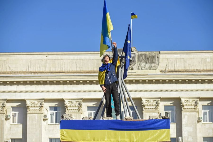 Ein Mann feiert die Rückeroberung von Cherson in der Ukraine.