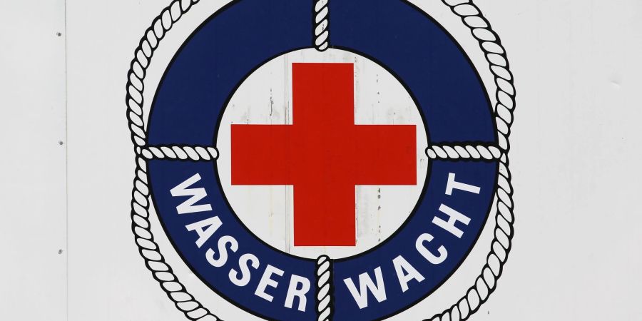 Das Logo der Wasserwacht des DRK an einem Rettungsturm im Ostseebad Warnemünde. Bis September halten die Rettungsschwimmer an bis zu zwölf Türmen Wache.