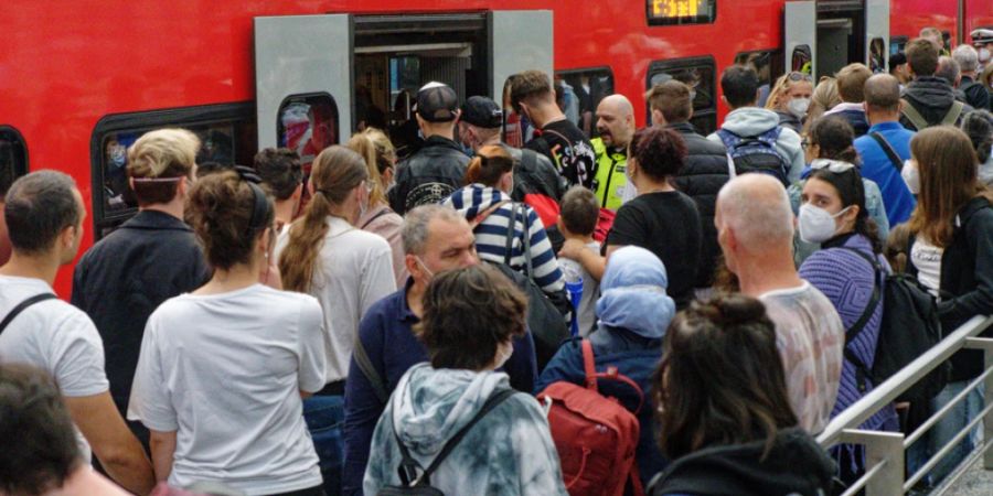 Reisende in Köln versuchen auf einem überfülltem Perron im Hauptbahnhof in einen Regionalzug zu steigen. (Archivbild)