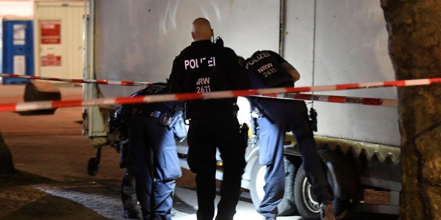 Polizisten suchen in der Nacht nach Spuren der Schiesserei auf dem Hamborner Altmarkt in Marxloh.