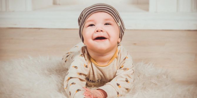 Baby Kleinkind Teppich fröhlich lachen