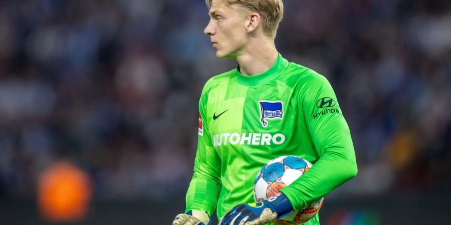 Herthas Torwart Oliver Christensen läuft mit einem Ball im Arm über das Spielfeld.