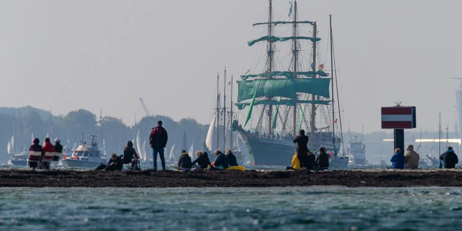 Zuschauer beobachten am Falkensteiner Strand die Windjammer-Parade der Kieler Woche. Die Stadt rechnet zum Sommerfest vom 18. bis 26. Juni mit einem Millionen-Publikum.