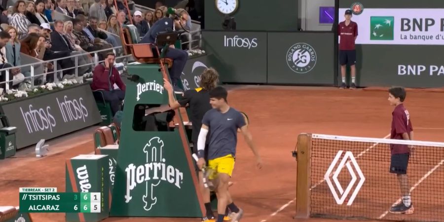 Während sich Tsitsipas beschwert, grinst Alcaraz schelmisch.