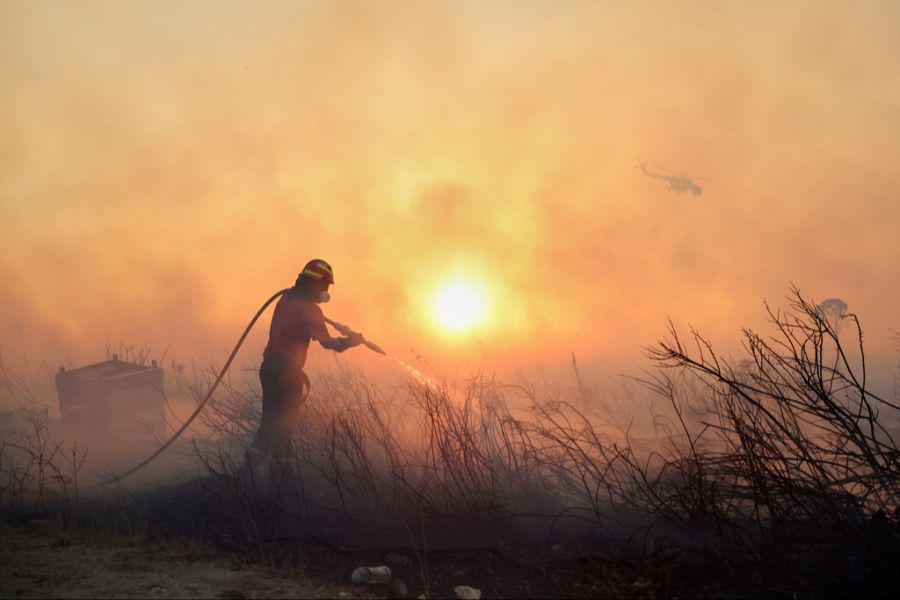 In Griechenland sind die Auswirkungen der Brände sichtbar. Starke Rauchschwaden hängen über den Dörfern. (Im Bild: Feuerwehr in Griechenland am 26. Juli 2025)