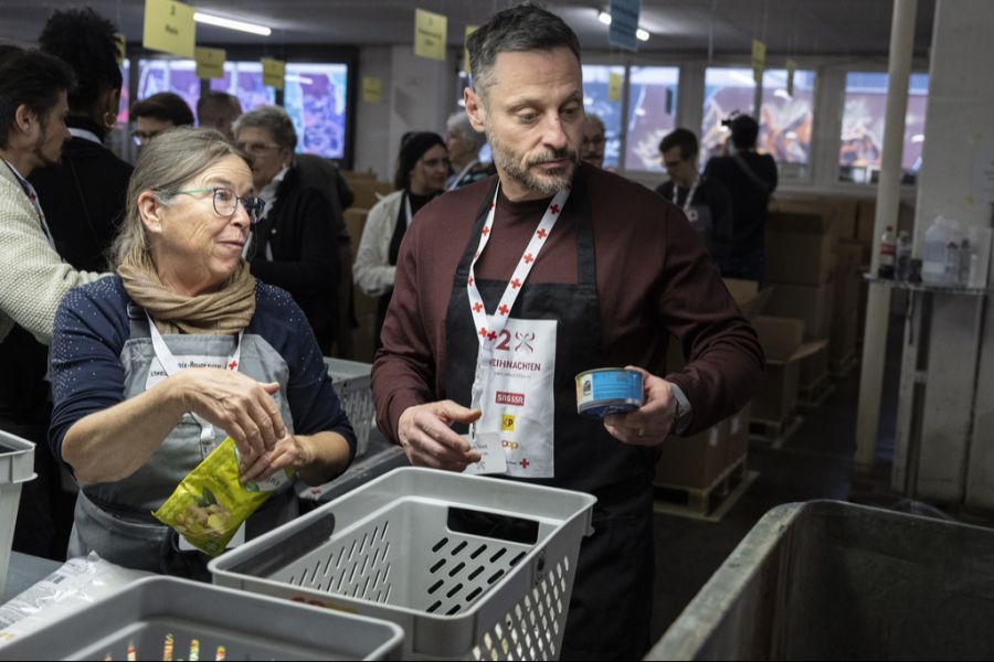 Bei der Aktion «2x Weihnachten» des Schweizerischen Roten Kreuzes (SRK) lässt sich der ehemalige Eishockeyprofi Mark Streit von SRK-Mitarbeiterin Maria Gallikar instruieren, am 7, Januar 2025 in Wabern BE.
