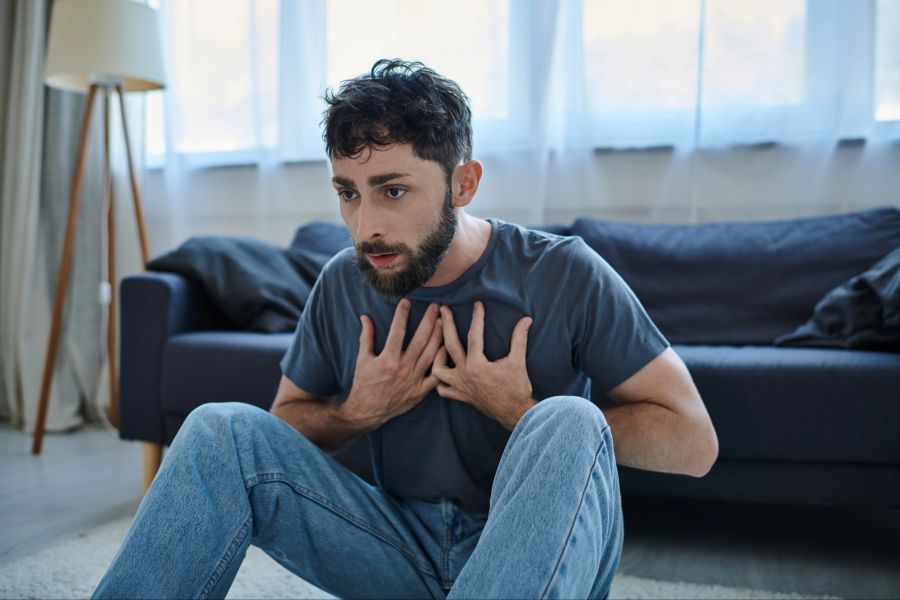 Mann mit Panikattacke im Wohnzimmer