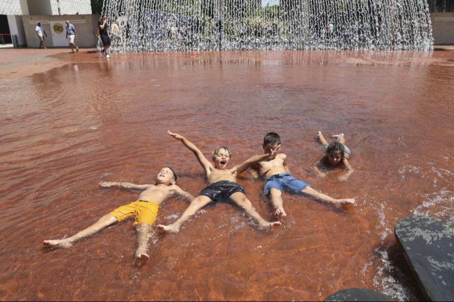 In Portugal kühlen sich die Kinder in einem grossen Brunnen ab.
