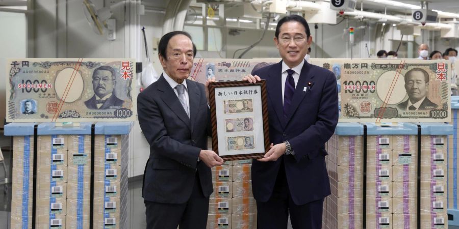 Japans Premierminister Fumio Kishida (r) und der Gouverneur der Bank of Japan, Kazuo Ueda, präsentieren die neuen Banknoten in Tokio.