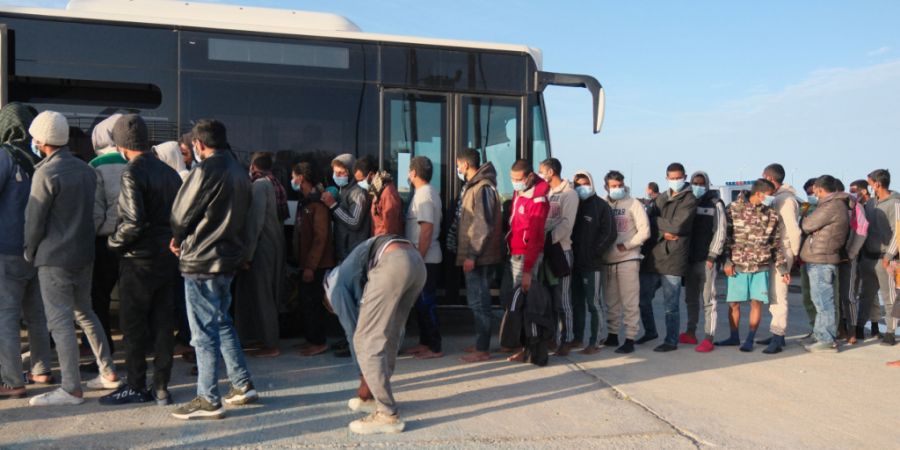 ARCHIV - Migranten gehen nach einer nächtlichen Rettungsaktion der Küstenwache im Hafen von Paliochora auf der Insel Kreta zu einem Bus. (Archivbild) Foto: Giannis Angelakis/AP/dpa