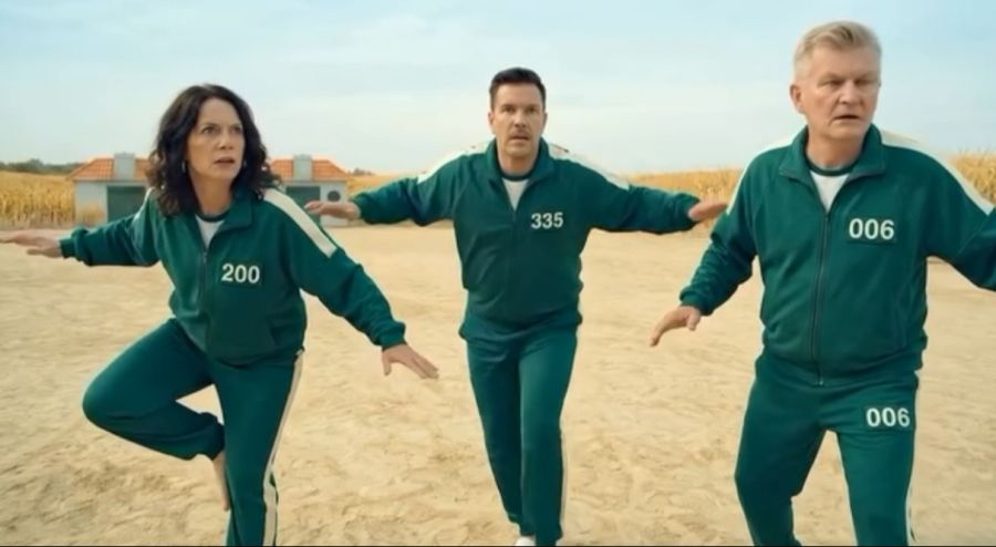 Und in einem Squid-Game wird Sven Epiney (M.) mit einem Pfeil aus einer Armbrust erschossen. Neben ihm sollen Mona Vetsch und Rainer Maria Salzgeber stehen (KI-generiert)