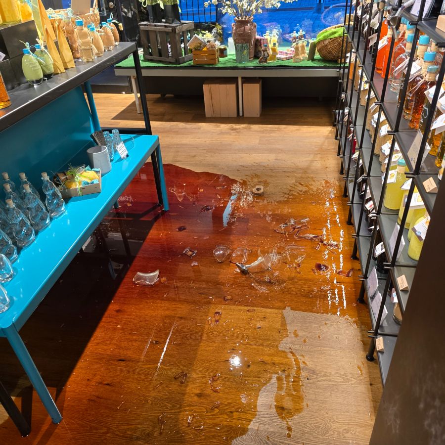 Eine riesige Pfütze mit Kaffeelikör und lauter Scherben liegen nach dem Likör-Malheur auf dem Boden des Geschäfts «Vom Fass» in Bern.