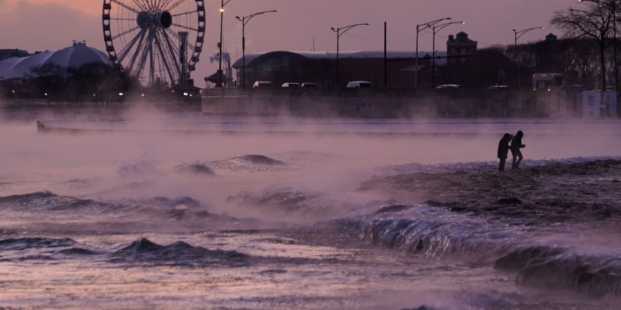 dpatopbilder - Menschen spazieren in Chicago über einen mit Eis bedeckten Strand am Ufer des Michigansees. Foto: Kiichiro Sato/AP/dpa
