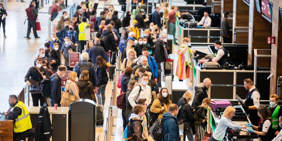 Passagiere stehen am Flughafen Berlin Brandenburg „Willy Brandt“ (BER) vor der Sicherheitskontrolle Schlange.