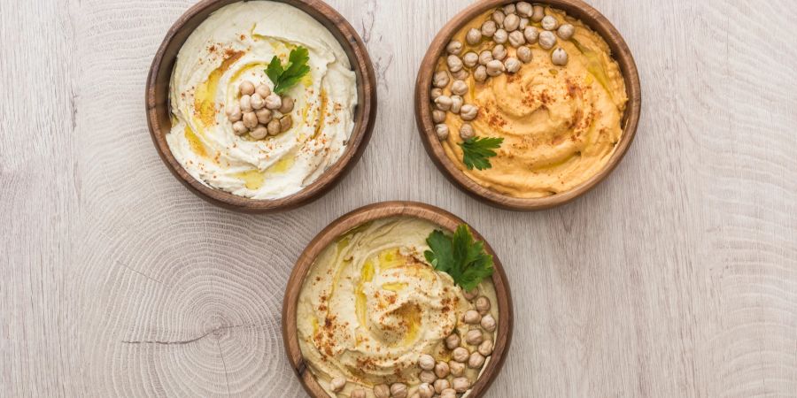 Drei verschiedene Hummus in Schalen.