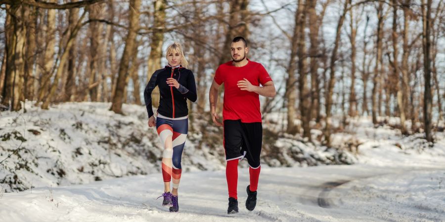 Mann und Frau joggen im Schnee