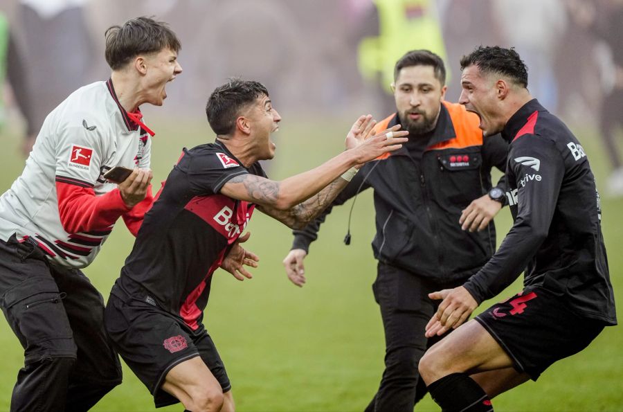 Fans, Spieler und Ordner – mit dem Titelgewinn herrscht bei Bayer Leverkusen plötzlich Durcheinander.