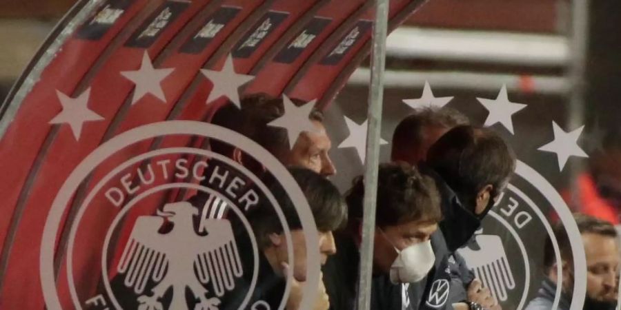 Hat bei Fans an Rückhalt verloren: Bundestrainer Löw (l) sitzt mit seiner Entourage beim Spiel gegen Spanien auf der Bank. Foto: Daniel Gonzales Acuna/dpa
