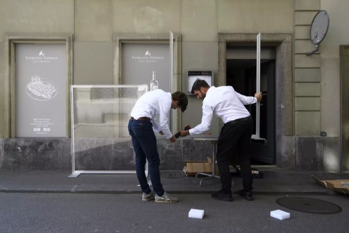 Zwei Mitarbeiter des Restaurants Entrecote Federale bauen ein Plexiglas-Schutz ein. (Archivbild) Coronavirus