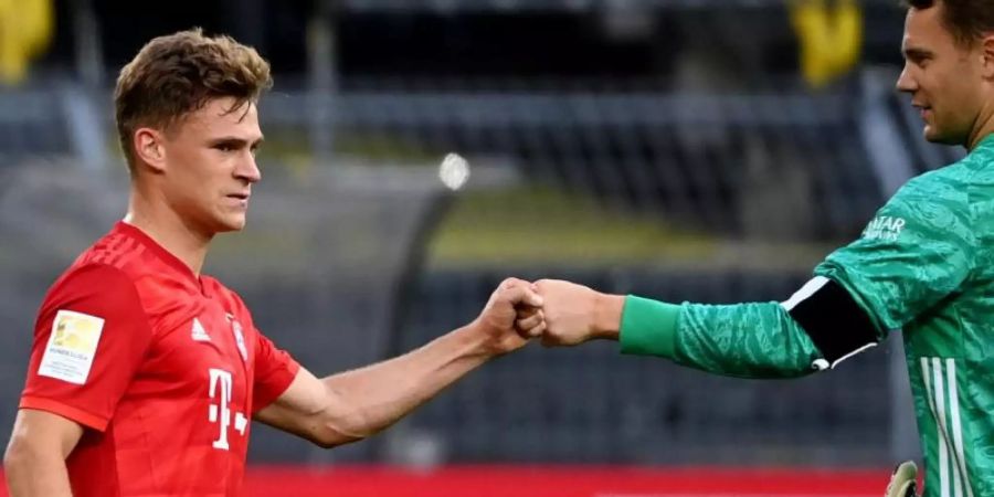 Joshua Kimmich (l) und Torwart Manuel Neuer grüssen sich mit der Faust. Foto: Federico Gambarini/dpa-Pool/dpa