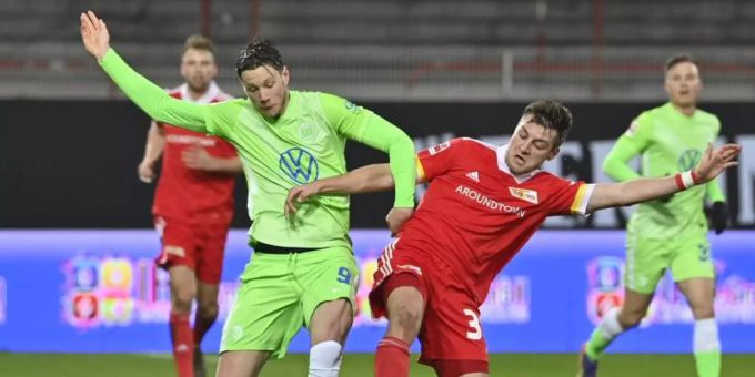 Robin Knoche (r) von Union Berlin im Duell um den Ball mit Wolfsburgs Wout Weghorst. Foto: John Macdougall/AFP-Pool/dpa