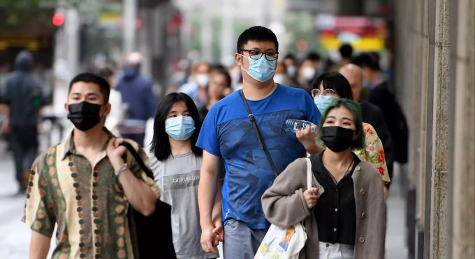 Menschen tragen Mund-Nasen-Bedeckungen auf einem Gehweg. Australiens bevölkerungsreichste Stadt Sydney reagiert mit weiteren Massnahmen auf den Anstieg bei neuen Corona-Fällen. Coronavirus - Australien