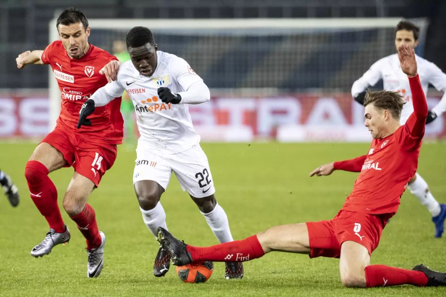 Vaduz-Verteidiger Joel Schmied (r.) grätscht gegen den Zürcher Angreifer Wilfried Gnoto (m.).