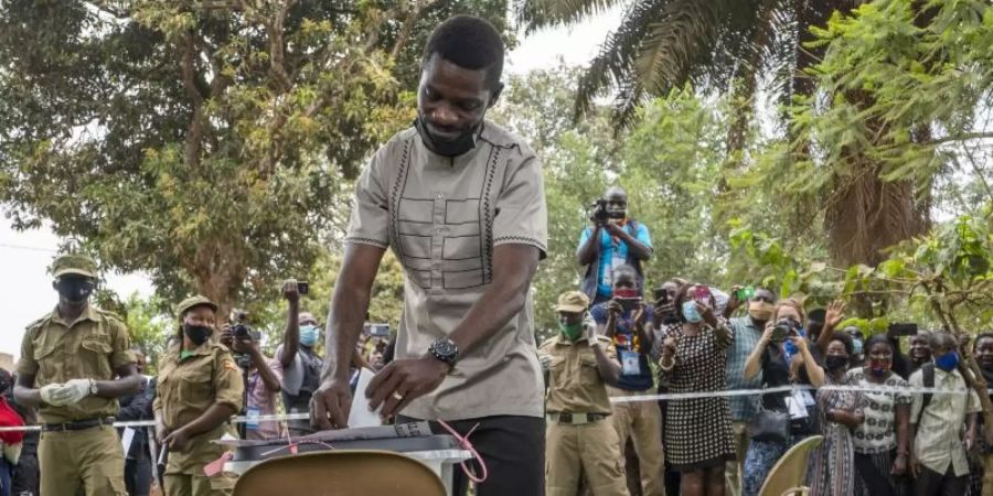 Bobi Wine, Popstar und Präsidentschaftskandidat der Opposition, mit bürgerlichem Namen Robert Kyagulanyi, gibt seine Wahlstimme während der Präsidenten- und Parlamentswahl ab. Foto: Jerome Delay/AP/dpa