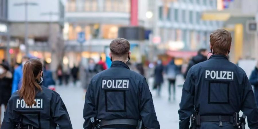 Polizisten kontrollieren die Einhaltung der Hygienevorschriften in der Innenstadt. Foto: Ole Spata/dpa