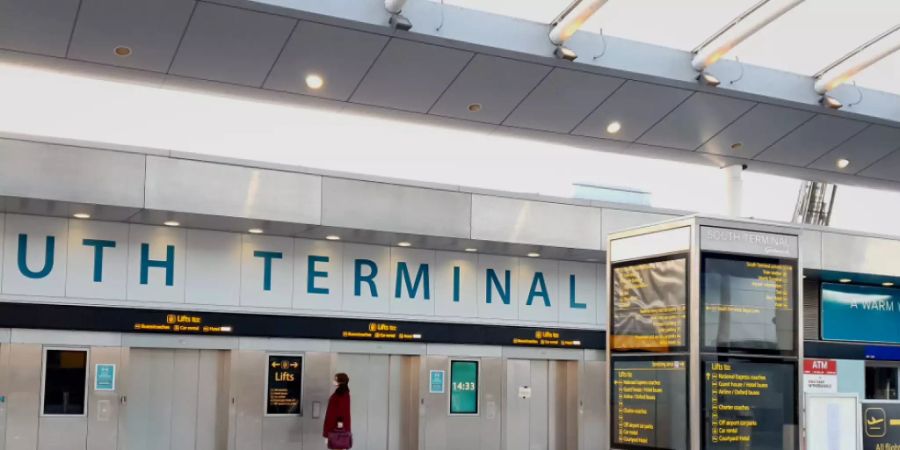 Eine Frau wartet im Süd-Terminal auf einen Aufzug im Flughafen Gatwick. Wegen der in Grossbritannien entdeckten neuen Variante des Coronavirus werden Flüge von dort nach Deutschland und in andere EU-Staaten weitgehend gestoppt. Foto: Gareth Fuller/PA Wire/dpa
