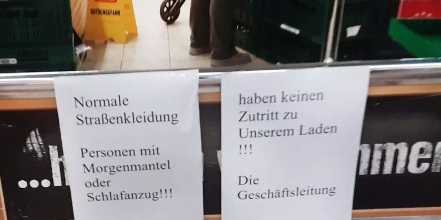 Hinweiszettel machen die Kundschaft in dem Duisburger Supermarkt auf die nun geltende Kleiderordnung aufmerksam. Foto: ---/privat/dpa