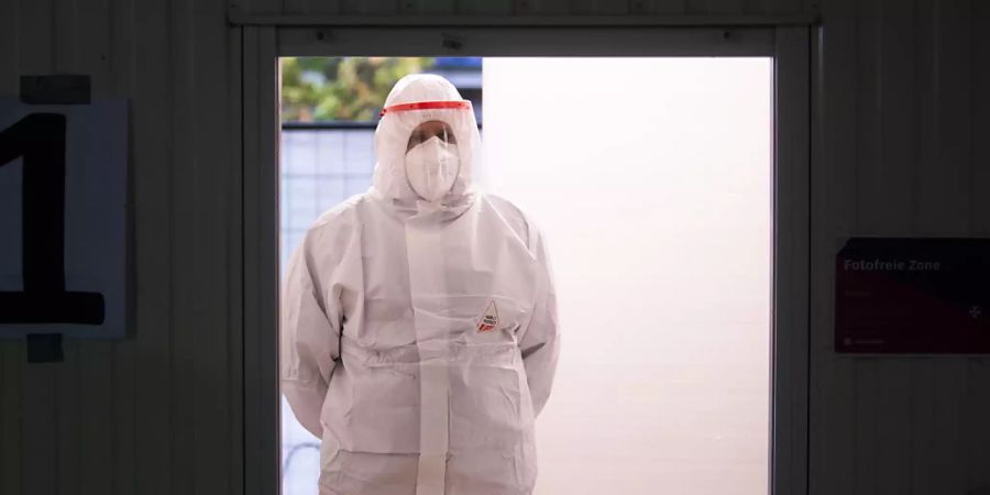 Ein Helfer der Johanniter wartet im Corona Testzentrum am Flughafen Hannover auf den nächsten Patienten. Foto: Julian Stratenschulte/dpa