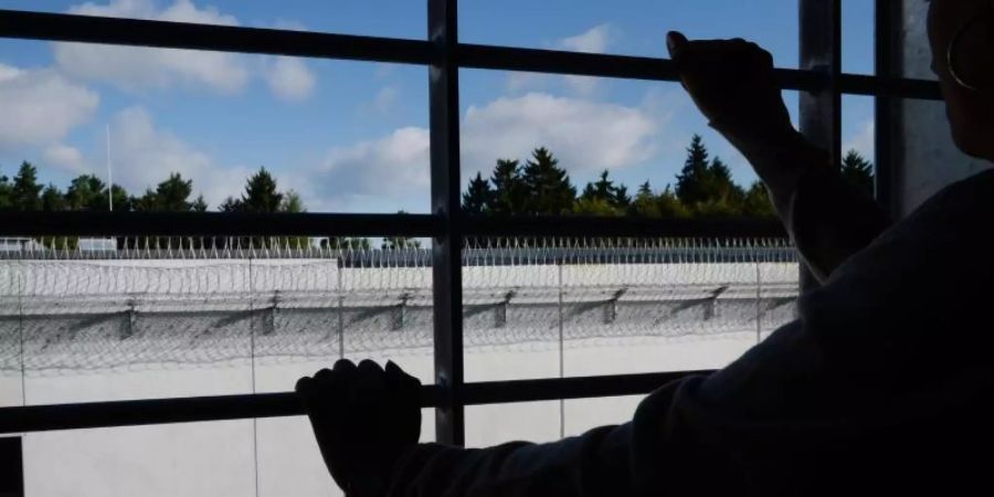 Ein Häftling steht an einem vergitterten Fenster in einer Zelle. Foto: Felix Kästle/dpa