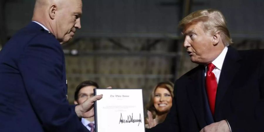 US-Präsident Donald Trump überreicht General Jay Raymond (l) die Ernennungsurkunde als Befehlshaber der neuen «Space Force». Foto: Andrew Harnik/AP/dpa