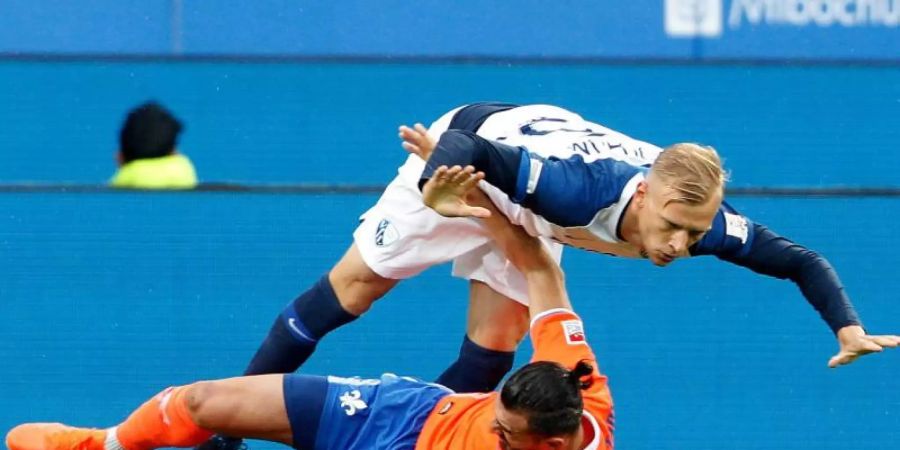Der Bochumer Saulo Igor Decarli wird vom Darmstädter Serdar Dursun von den Beinen geholt. Foto: Roland Weihrauch