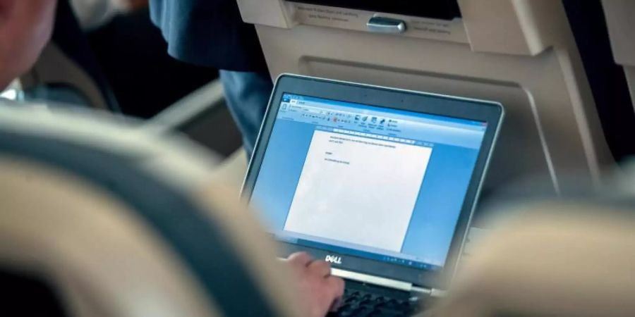 Während des Fluges am Laptop arbeiten zu können, ist vor allem für Geschäftsreisende wichtig. Noch sind die Bandbreiten jedoch gering und die Gebühren hoch. Foto: Michael Kappeler/dpa