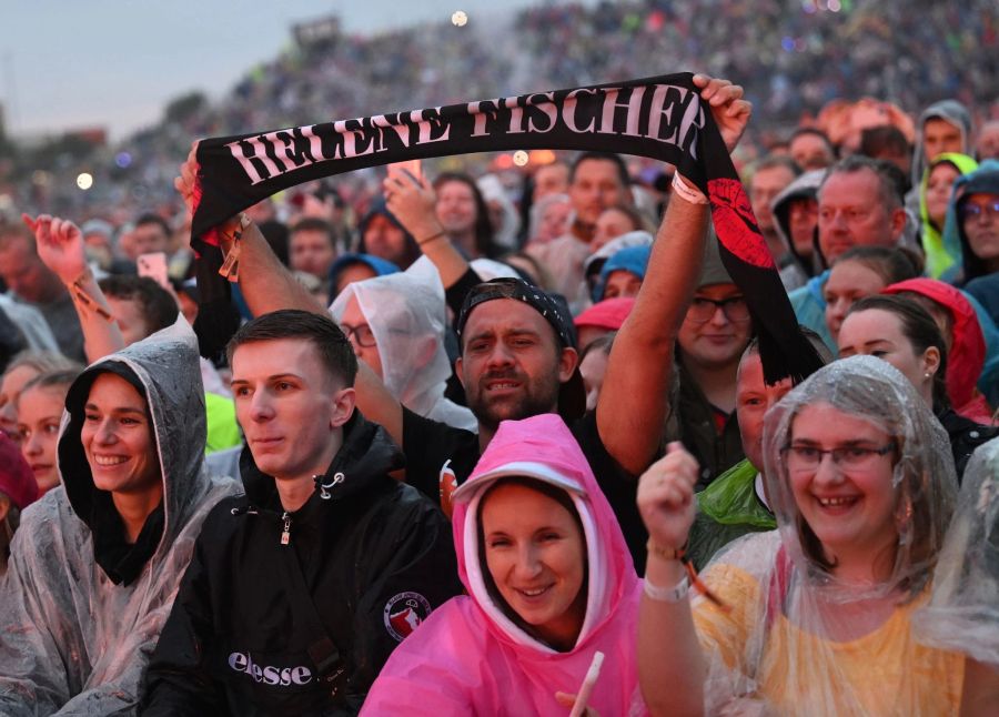 Eine Rekordzahl von 130.000 Fans feierte mit Regenponchos im strömenden Regen.