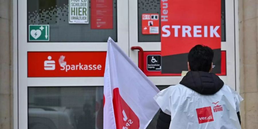 Streikpotsten vor der Tür der Sparkasse Märkisch-Oderland in Strausberg. Foto: Patrick Pleul/dpa-Zentralbild/dpa