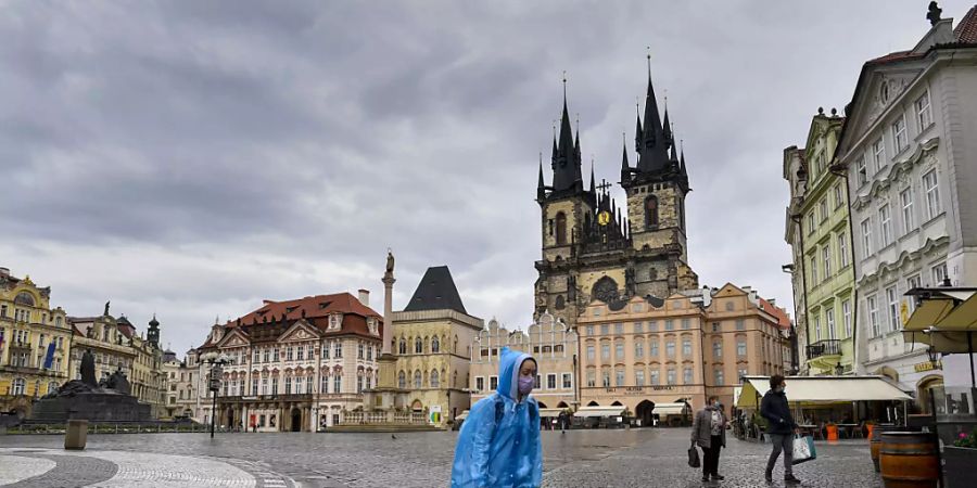 ARCHIV - Eine Frau geht bei Regen durch die fast menschenleere Altstadt. (Archivbild) Foto: VÌt ?im·nek/CTK/dpa