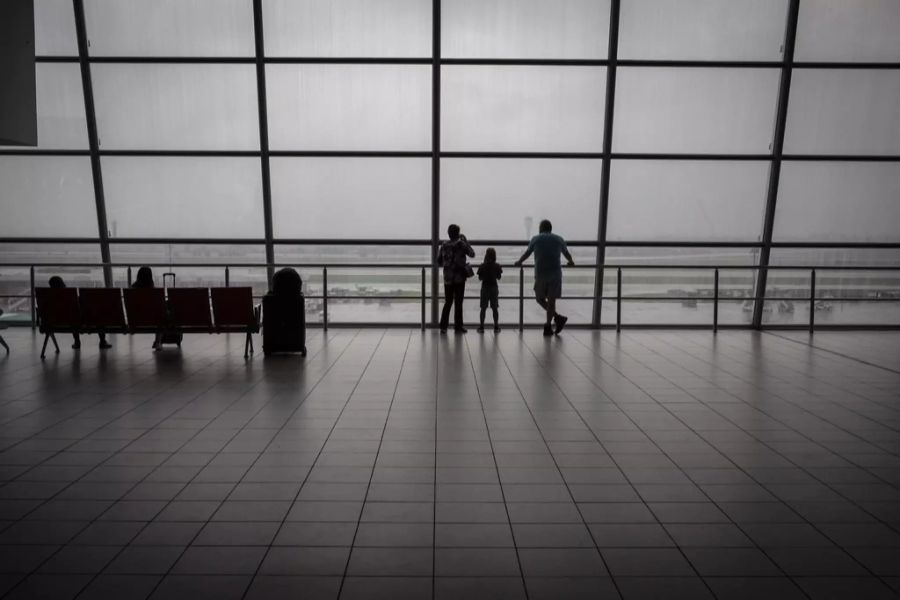 Reisende blicken am Flughafen in Johannesburg auf die Start- und Landepiste.