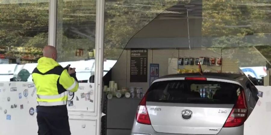 Fassade durchbrochen: Das Auto, gesteuert von einem kleinen Jungen, steht in einer Tankstelle in Bochum. Foto: Markus Gayk/dpa