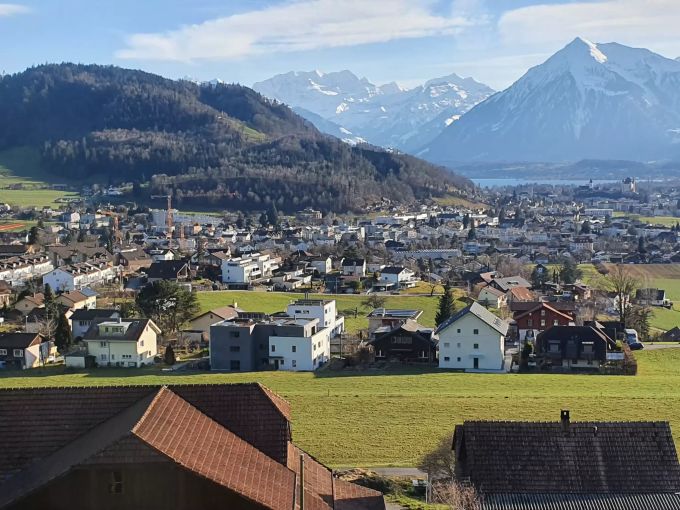 Blick vom Naherholungsgebiet Hartlisberg über Steffisburg nach Thun mit Thunersee, Niesen und Blümlisalp im Hintergrund. Steffisburg