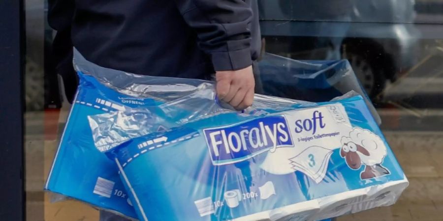 Mann trägt Toilettenpapier durch Berlin-Kreuzberg