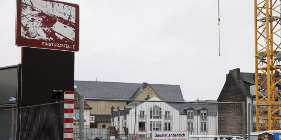 Ein Schild mit dem Hinweis auf die Einsturzstelle des Kölner Stadtarchivs hängt am Bauzaun in Köln. Foto: Oliver Berg/dpa