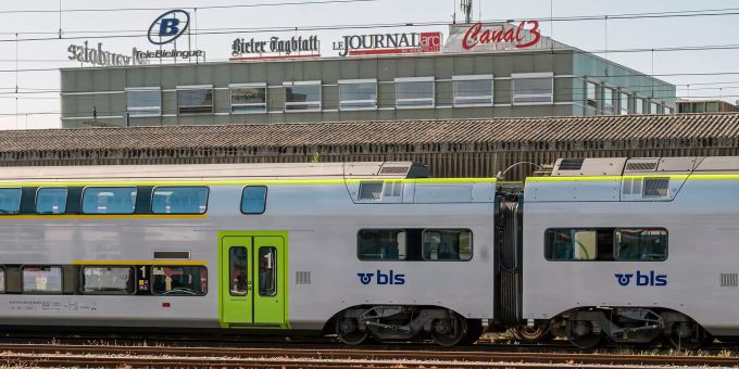 A BLS regional train in Biel station.  In the background the Gassman Media AG building.