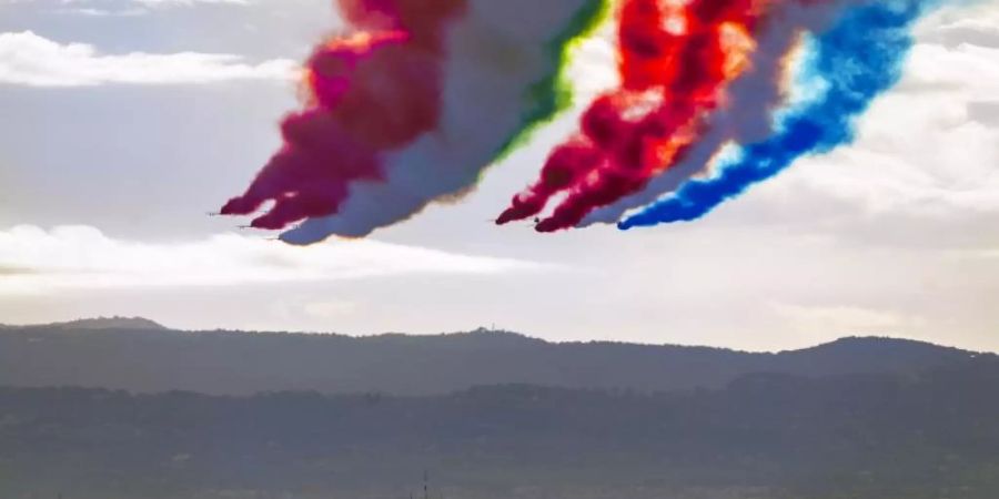 Die italienische Kunstflugstaffel «Frecce Tricolori» (links) und die Kunstflugstaffel der «Patrouille de France» hinterlassen am Himmel Kondensstreifen in den Farben der italienischen und französischen Nationalflagge. Foto: Domenico Stinellis/AP Pool/dpa