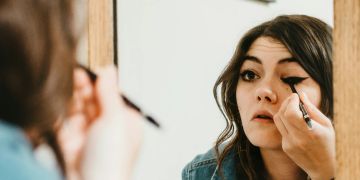 frau eyeliner im spiegel