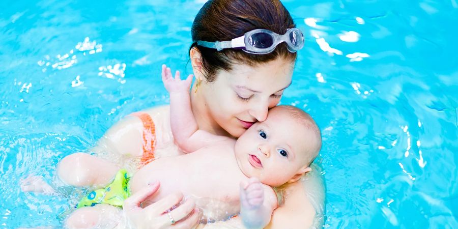 Mutter mit Baby auf dem Arm im Wasser